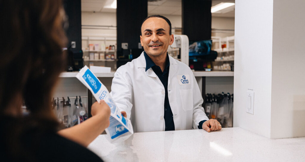 Pharmacist handing medication over the counter 